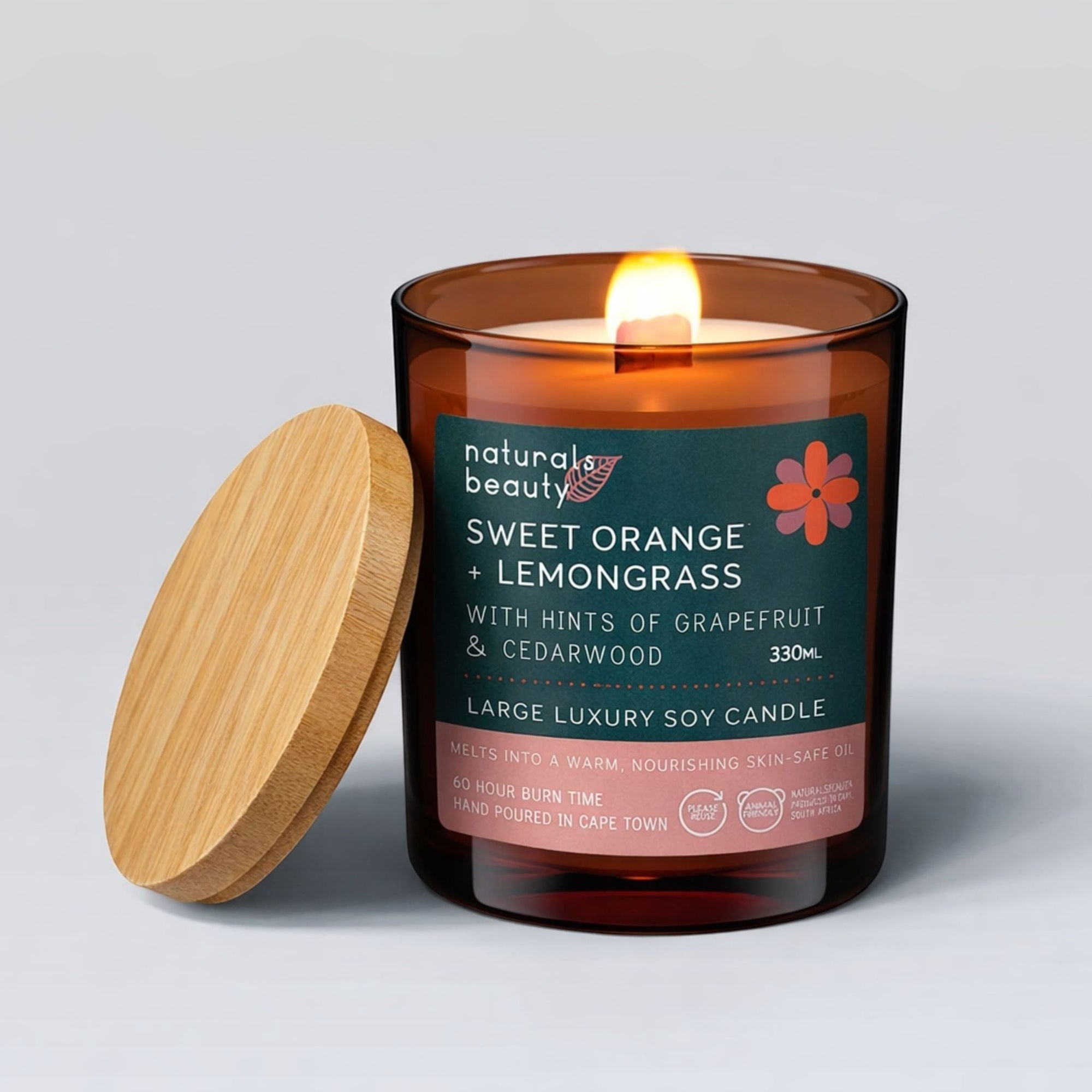 Lit candle in a glass jar with a wooden lid on a light gray background