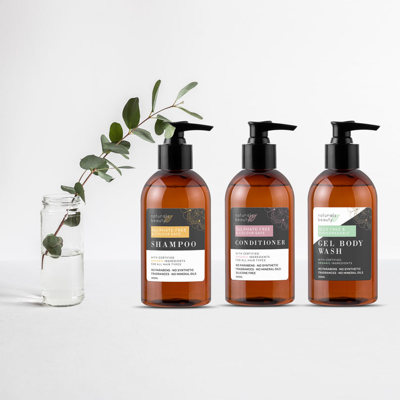 Three bottles of shampoo, conditioner, and gel body wash with labels on a white background.