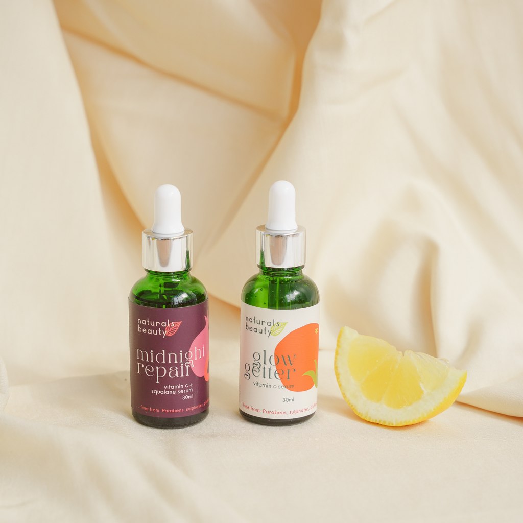 Two green bottles with droppers labeled 'midnight repair' and 'glow getter' organic ingredients.