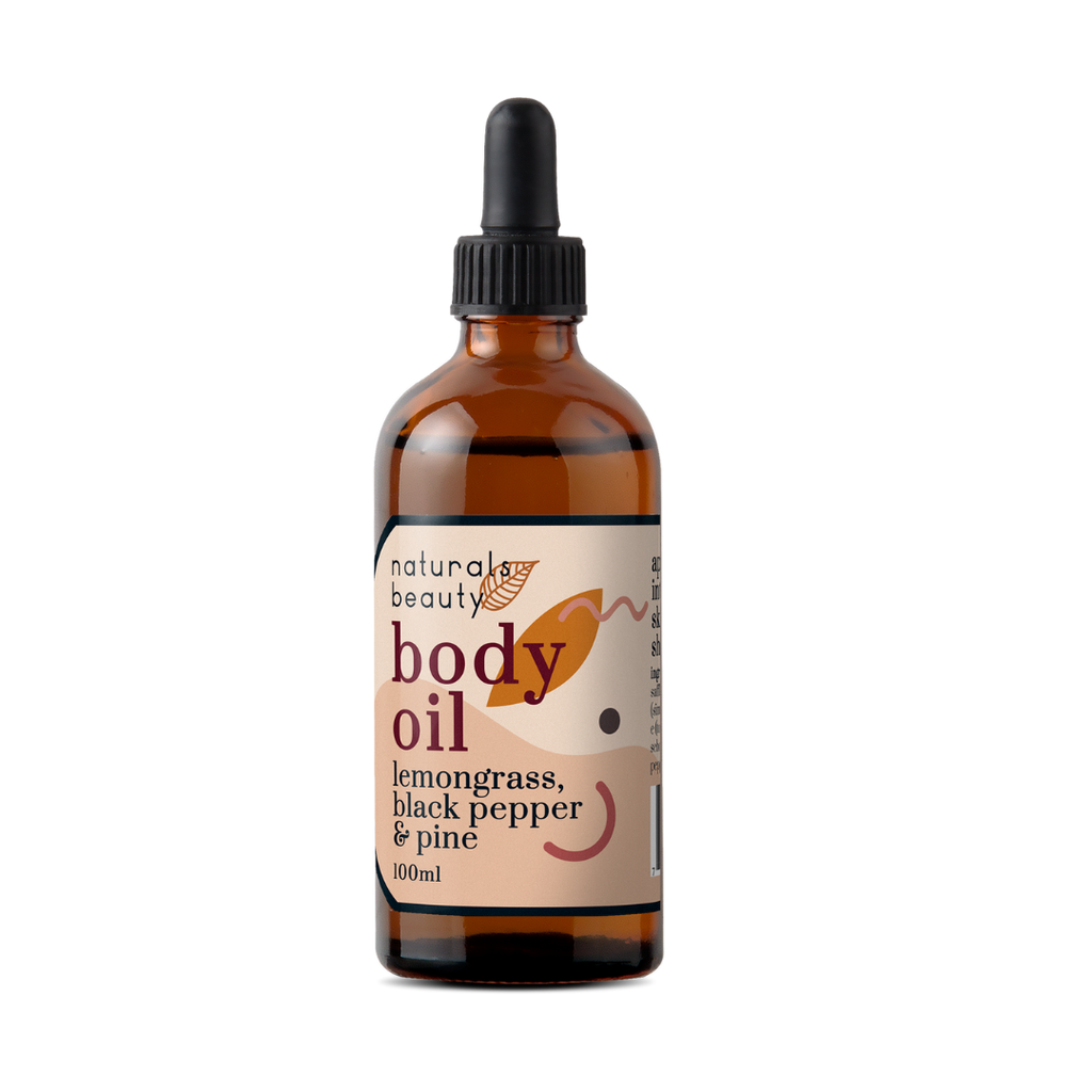 Glass bottle of organic body oil with lemongrass, black pepper & pine with a dropper labeled 'naturals beauty' on a white background